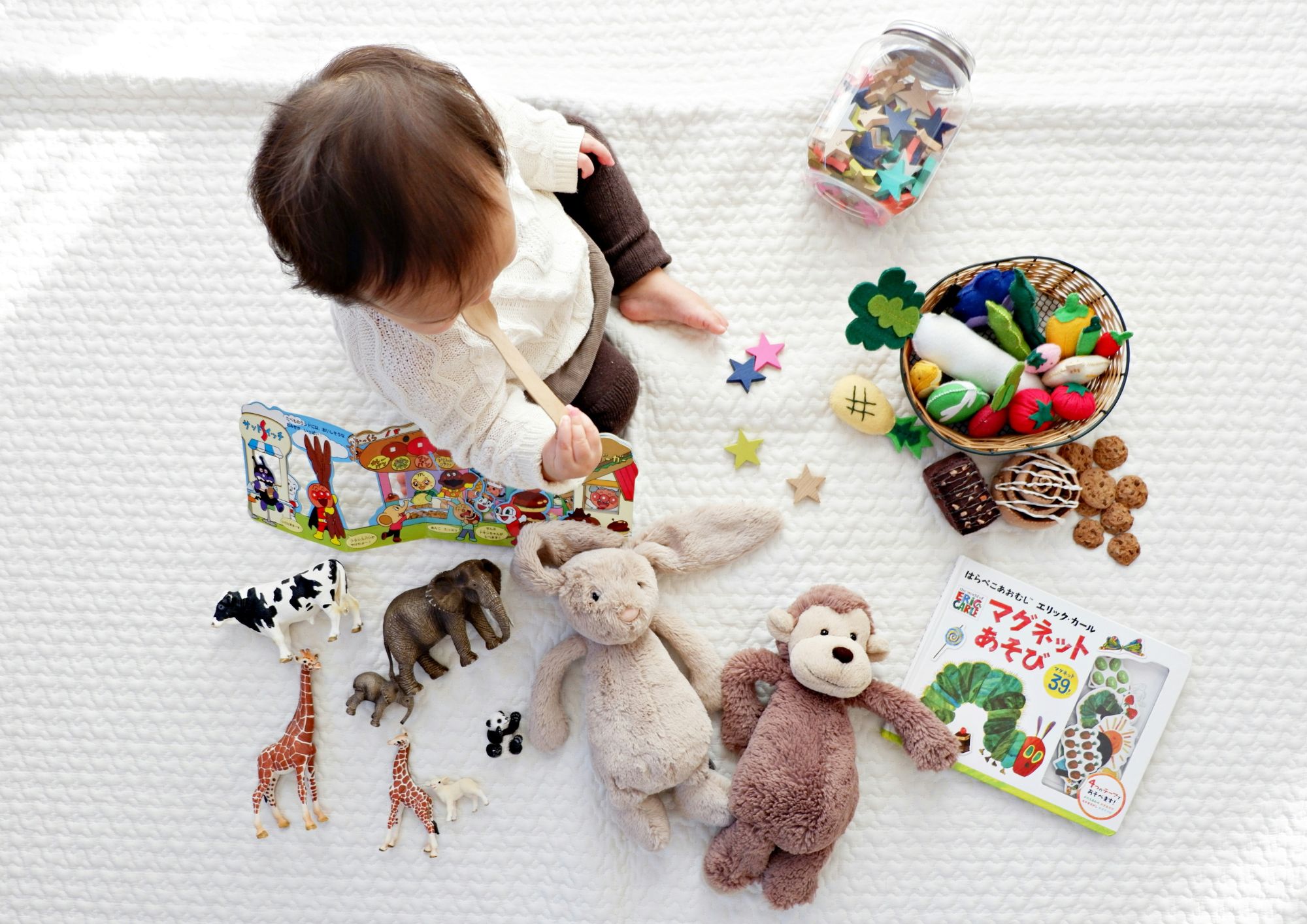 one year old toddler surrounded by toys